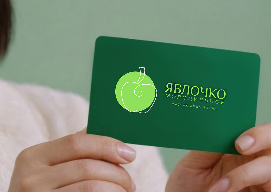 Карточка-абонемент салона Яблочко молодильное, которую держит в руках девушка.